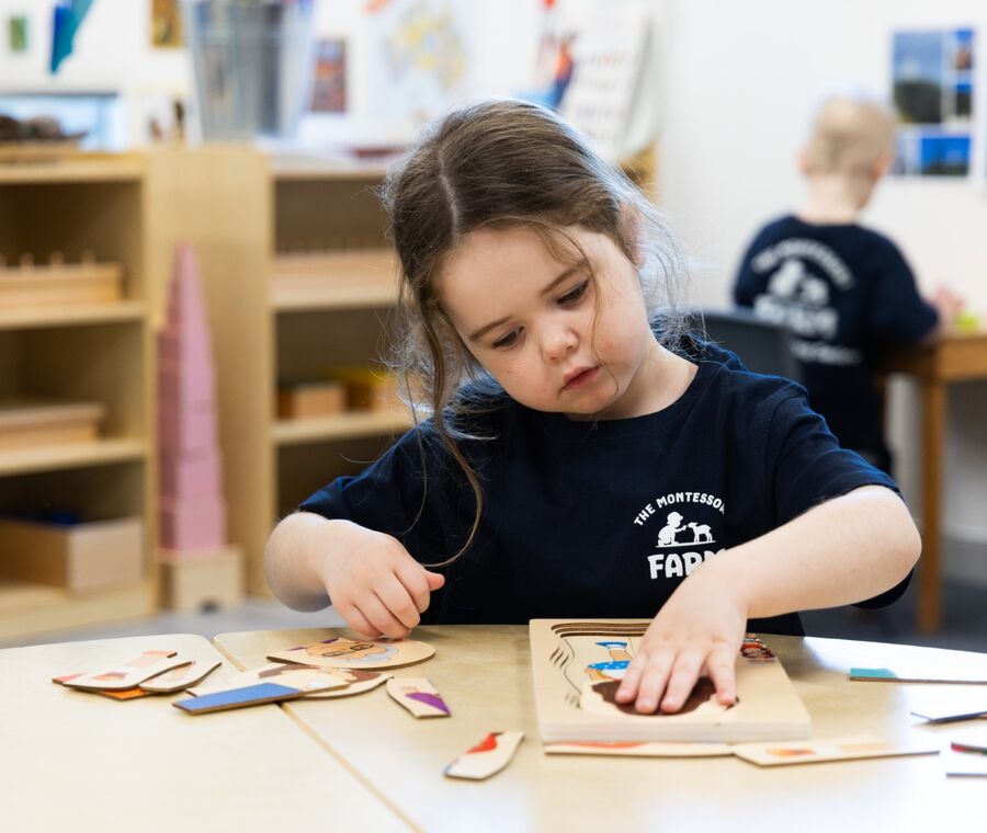 A child working with Montessori learning materials at a table
