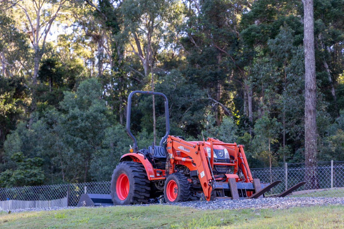 The farm tractor by the trees