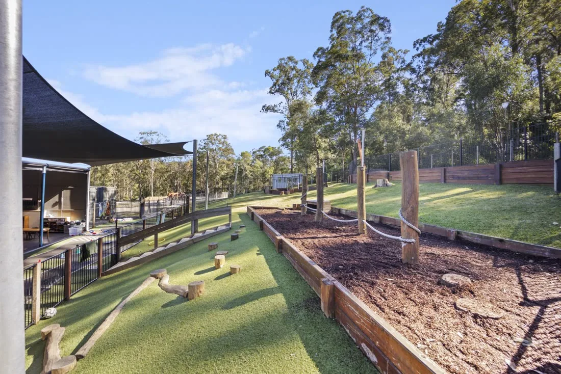 The shaded natural playground with garden beds