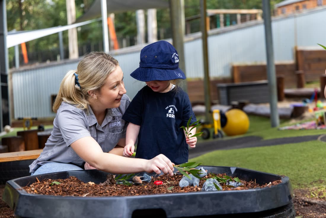 Sensory play in the mud kitchen with an educator