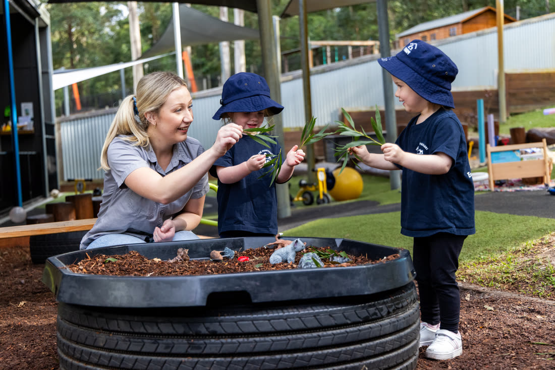 An educator and children exploring the sensory garden bed