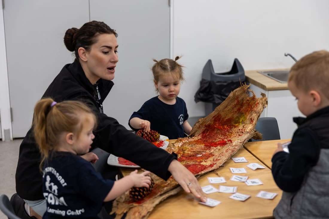An educator and children exploring natural materials together