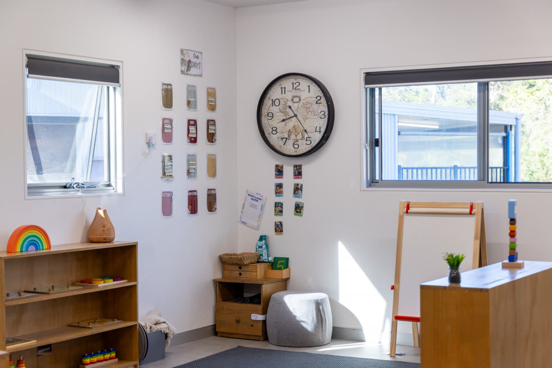 A quiet corner of the classroom with shelves, clock and easel