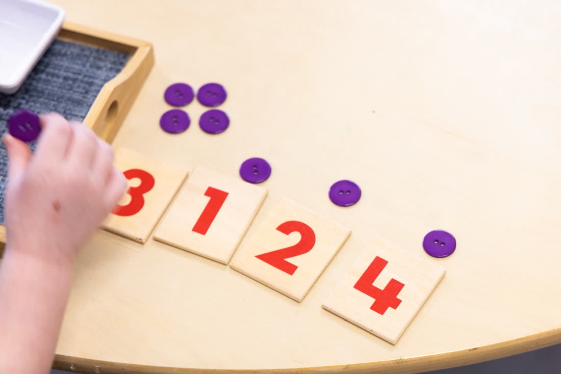 A child learning numbers with counters and cards